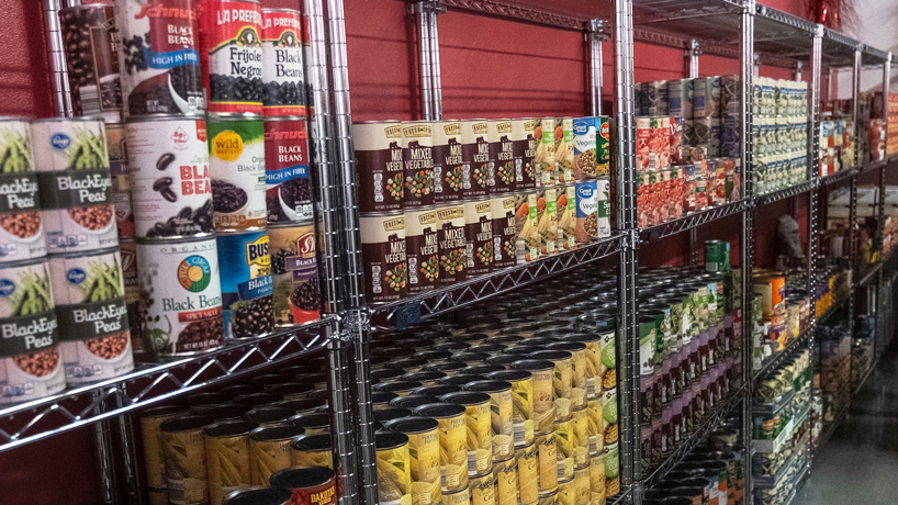 Canned goods stacked on shelves of food pantry