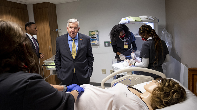 Sen. Brian Williams (left) and Gov. Mike Parson Gov. Mike Parson (center) observes UMSL BSN students in the new College of Nursing Simulation Labs. (Photo by August Jennewein)