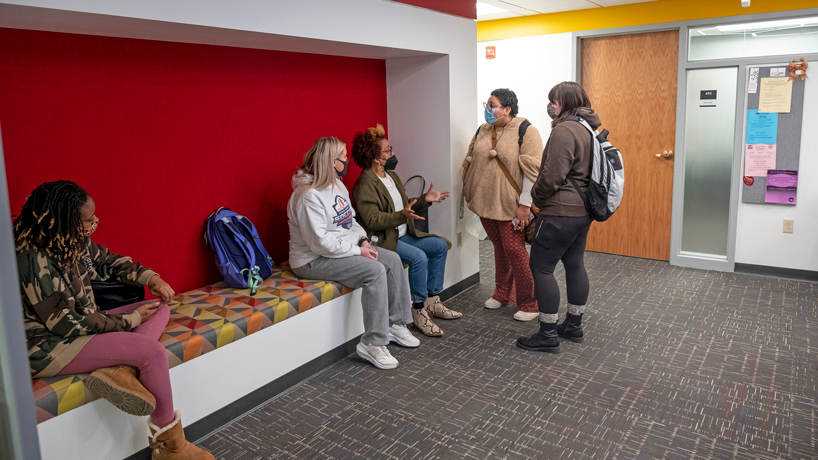 Students chat with each other in the lobby of the newly renovated School of Social Work office suite in the Social Sciences and Business Building