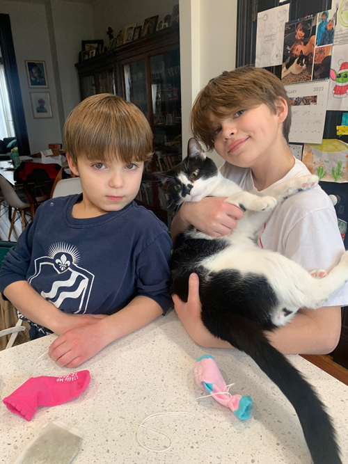 Theo and Elliot Hart pose with Oskar the cat