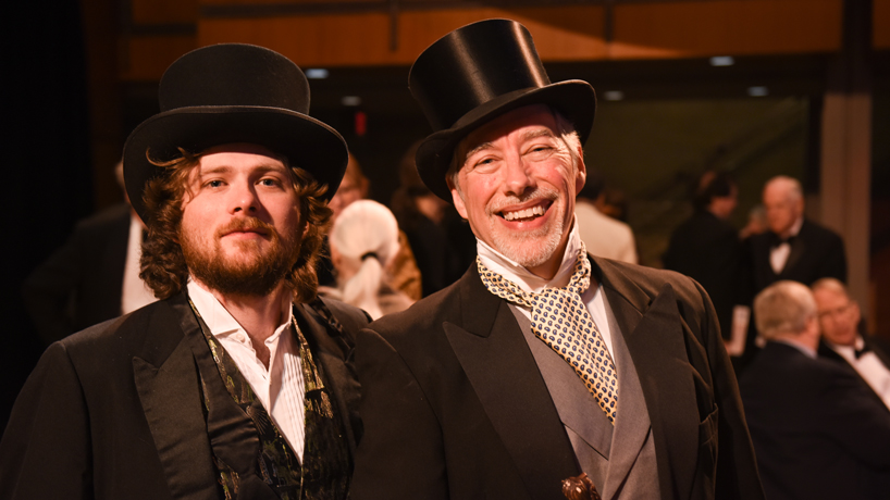 Two men in tuxedos and top hats