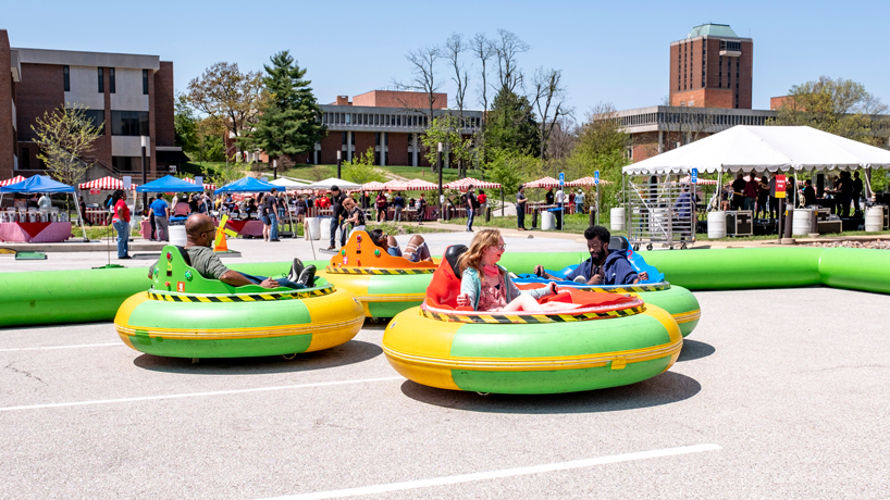 Students ride in bumper cars outside the Recreation and Wellness Center during Mirth Week