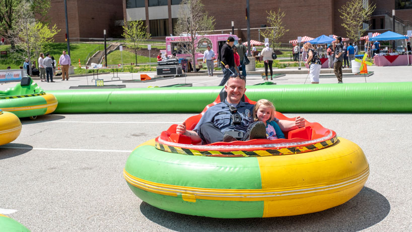 Police Officer Dustin Smith riding in a bumper car with his daughter