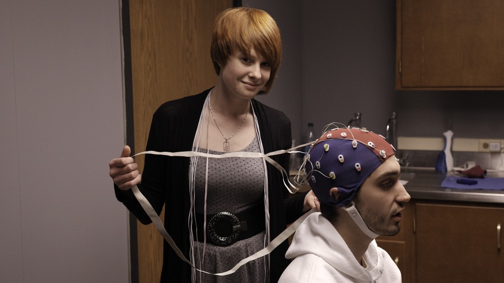 Neuroscience student Emma Trammel demonstrates how she tests a research subject's brainwaves. (Photo by August Jennewein.)