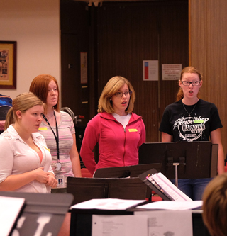 Carrie Walther (pink jacket) is a music education major and the student director of the newly formed Women's Chorale.  (Photo by August Jennewein)