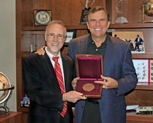 Chancellor Tom George (left) presents the E. Desmond and Mary Ann Lee Medal for Philanthropy to Emerson Chief Executive Officer and Chairman David Farr, who accepted the award on behalf of the corporation.