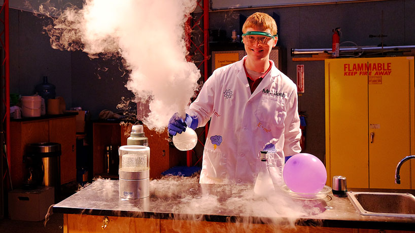 Alumnus Josh Linn demonstrates the "Boiling hot, boiling cold" experiment at the Saint Louis Science Center, where he is senior educator of Center Stage. The liquid nitrogen, so cold that it boils, vaporizes dramatically when it comes in contact with boiling hot water. He conducts and explains experiments like these on live TV for KSDK (Channel 5) and KTVI (Fox2) science segments. (Photos by August Jennewein)