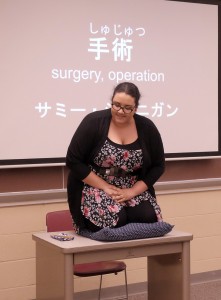 Pierre Laclede Honor College junior Samantha Jarnagin performs her skit where she plays both a patient and doctor who are new to surgery. The towel and fan to her right are traditional Rakugo props that, through the use of skilled acting and pantomime, may be transformed into items such as chopsticks or a book.