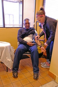 Bennett checks the blood pressure of a man after having his hair done. Likewise, Bennet also plans to go into obstetrics and gynecology after she graduates this spring.