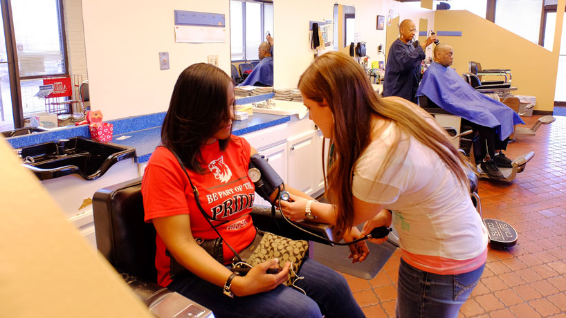 Senior nursing student Amy Linck takes checks the blood pressure of a Womack's Barber and Beauty Style regular in Jennings, Mo. (Photos by August Jennewein)