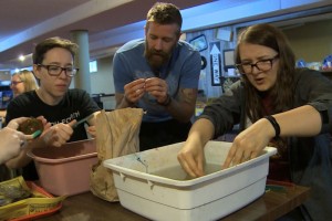 Using toothbrushes and water, Pierce and UMSL students clean artifacts unearthed earlier in the day.