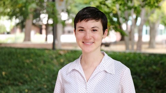 Grad student Jenny Connelly-Bowen stands on the Quad with trees in the background.