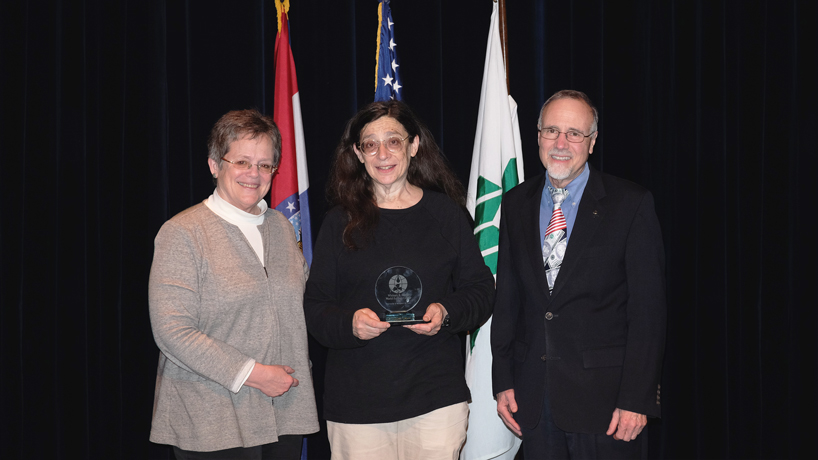 Chancellor Tom George (at right) and UMSL's Whitney R. Harris World Ecology Center Interim Director Patty Parker (at left) present entomologist May Berenbaum (center) her award after Berenbaum gave the 2017 Jane and Whitney Harris Lecture at the Missouri Botanical Garden. (Photos by Marisol Ramirez)