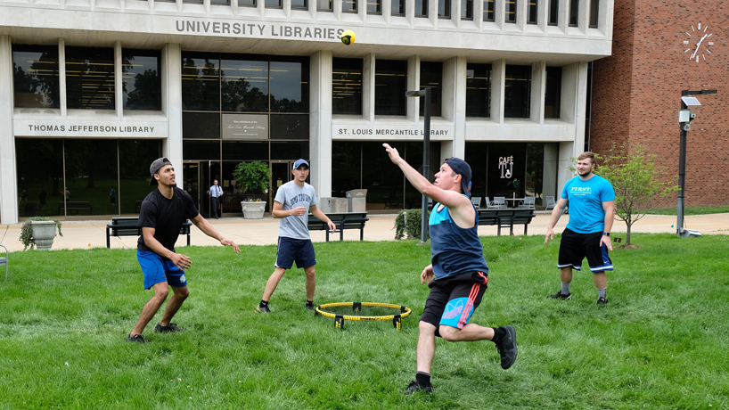 Nursing students (from right) Nick Schueddig, Nick Rangel and Chris Galvin and friend Brett Wright playing Spikeball in front of Thomas Jefferson Library