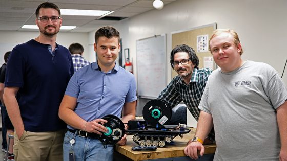 Mechanical engineering seniors Corey Milcic, Jonathan Olson and Kristian Stavri built a robot that lays extension cord during their capstone course. (Photos by Jessica Rogen)