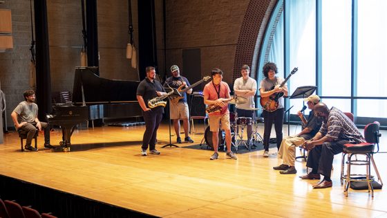 UMSL Jazz Combo members (from left) Ethan Saake, Trae Riley, Mike Owens, Nick Brothers, Dietrich Plyler and Nick Ayala as well as jazz pianist Sharp Radway (far right) listened to tales from behind the music from jazz legend Benny Golson. (Photos by August Jennewein)