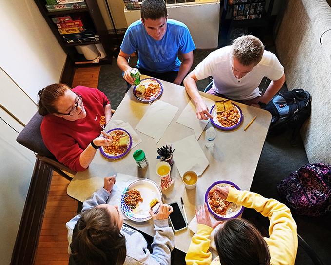Residents of the upperclassmen Honors College dorm, Villa North Hall, (clockwise from left) Jenna Haddock, Simon Langrehr, alumnus Tanner Emring, Maddie Woodham and Madison Koogler gather for a meal.