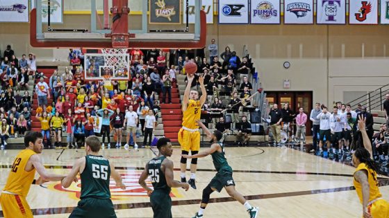 UMSL men's basketball player shoots three-pointer