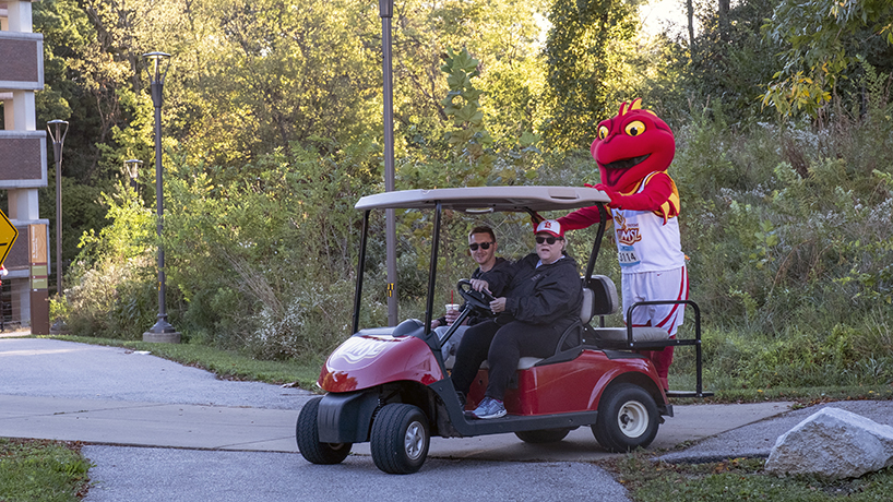 Louie the Triton catches a ride with Chancellor Kristin Sobolik 