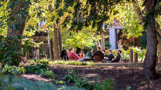 Philosophy Professor Eric Wiland holds class with his students while seated outside in the Quad