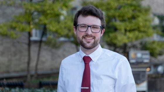 Evan Price stands on campus