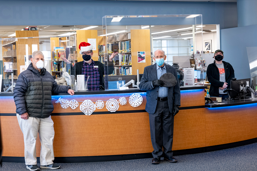 From left, Bernard Waxman, Ted Fiklen, John Samet and Katie Brown stand near the front desk at University Libraries