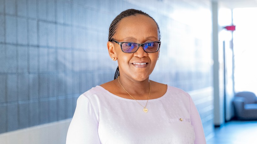 African American woman with glasses stands and smiles