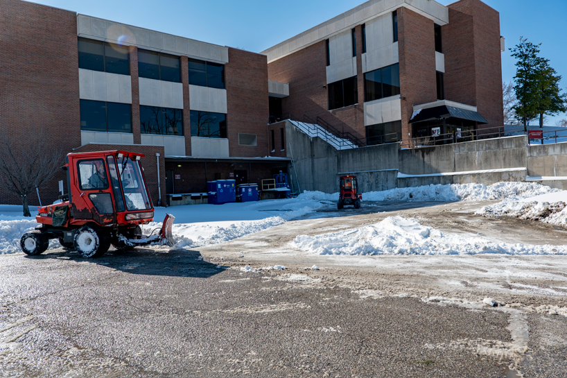 Crews clear snow near the loading dock on the north side of the J.C. Penney Building