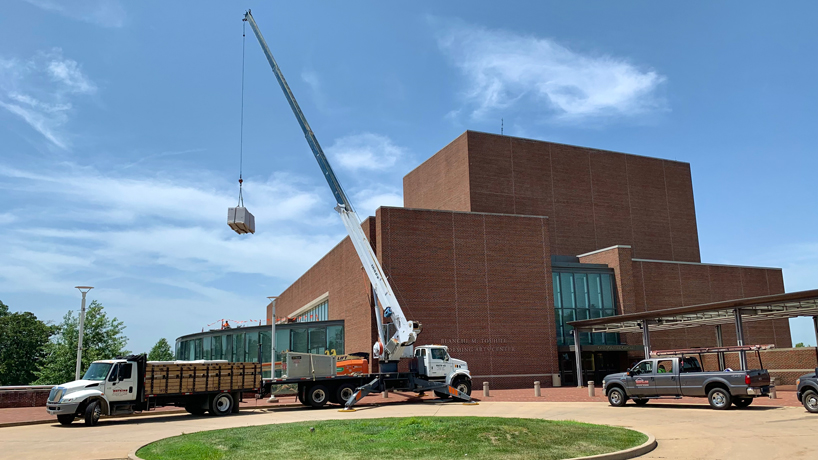 A crane lifts insulation onto the roof of the Blanche M. Touhill Performing Arts Center