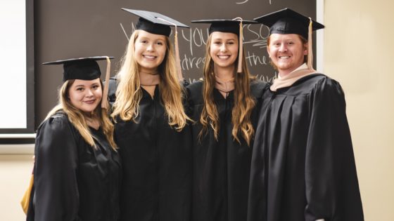 University of Health Sciences and Pharmacy students Abby Herman, Leah Blocker, Jessica Kirk and Carson VonAlst stand in their caps and gowns