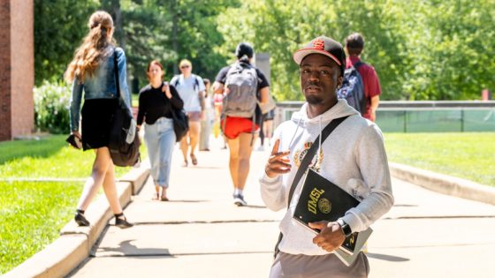 Caleb Wilkerson flashes a peace sign while stopping near the Thomas Jefferson Library on the first day of class