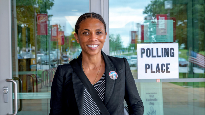 Jody Squires standing in front of the Polling Place sign at the MSC