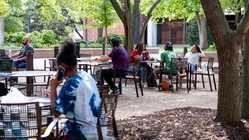 Students relax in the shade of the Quad during the first week of the fall semester