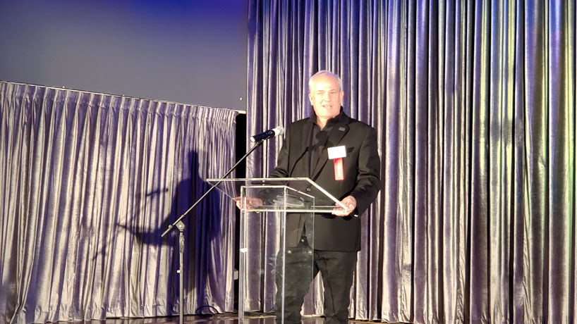 Dan Lauer stands at podium giving acceptance speech