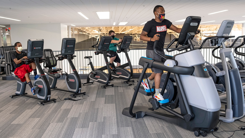 three men on eliptical machines workout at the recreation and wellness center