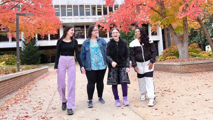 UMSL Social Peers Program participants Jessica Probert, Destiny Trent, Alexandra Psujek and Tema Gholston-Byrd chuckle together as they walk through the Quad