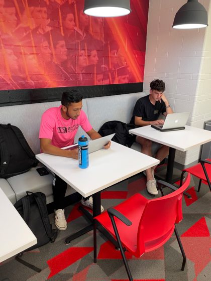 Two student-athletes study at two tables in the new student-athlete academic commons