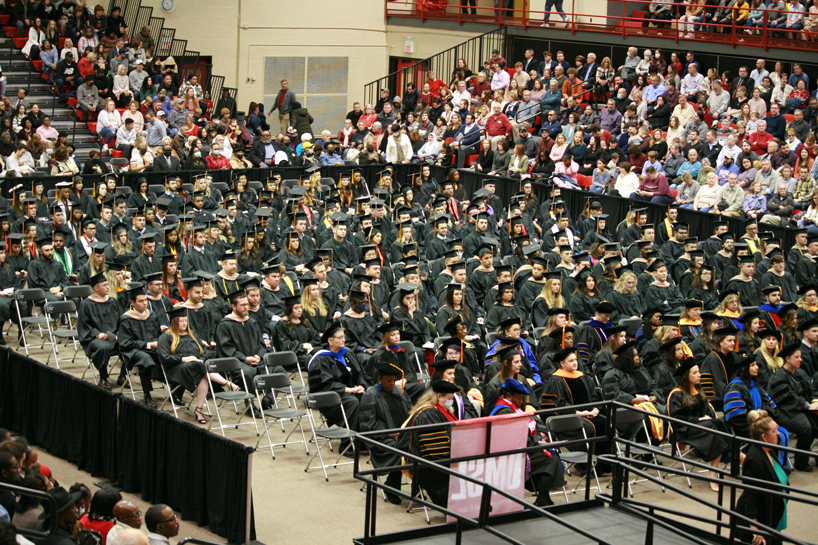 Graduates of the College of Business Administration and College of Nursing fill the seats on the floor of the Mark Twain Athletic Center