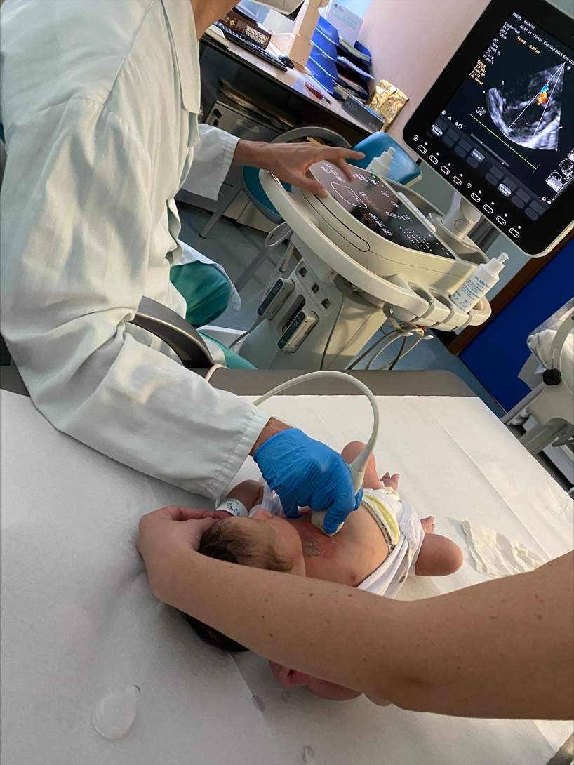 Christina Karam assists with EKG on newborn