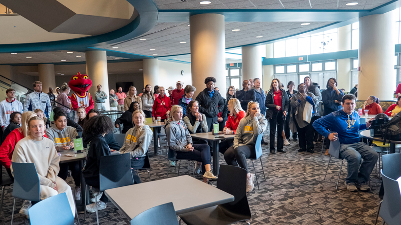 Students, faculty and staff members and alumni attend a pep rally for the UMSL men's basketball team in the lower level of the Millennium Student Center