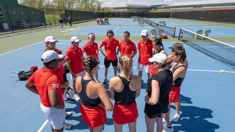 Members of the UMSL men's and women's tennis teams huddle together before their matches against Illinois Springfield
