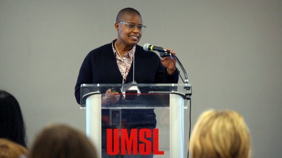 Educator and author Kimberly N. Parker adjusts the microphone while speaking behind a clear UMSL lectern