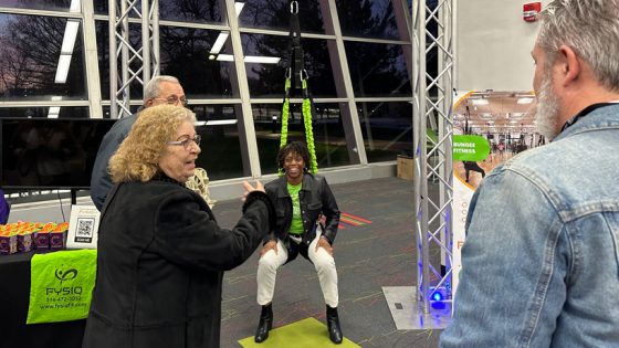 Misha Gutzler shows off the bungee fitness equipment at DEI Accelerator Demo Day