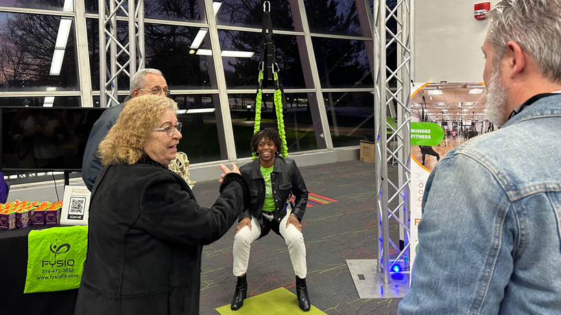 Misha Gutzler shows off the bungee fitness equipment at DEI Accelerator Demo Day