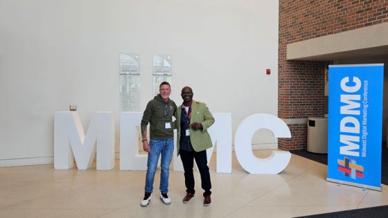 Perry Drake stands with his colleague, Vernon Ross in front of the large letters, MDMC.