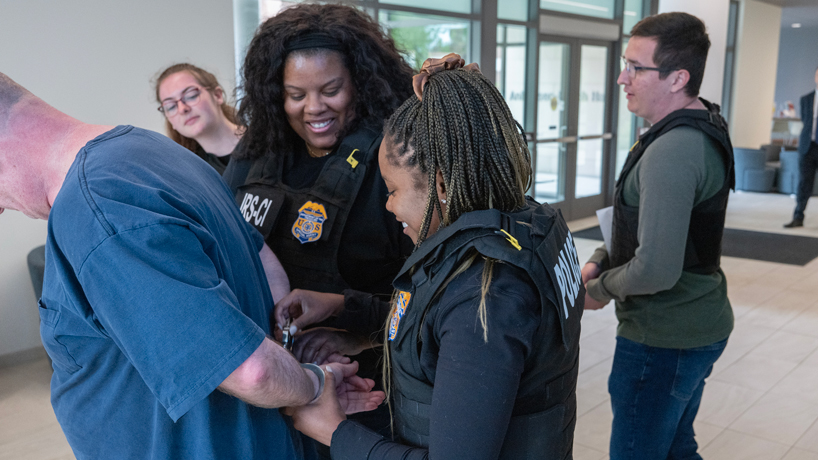 Jarchelle WIlliams and Desiree Brooks arrest a suspect during an arrest warrant scenario. Dora Bell (at left) and Gesi Muzhaqi watch in the background