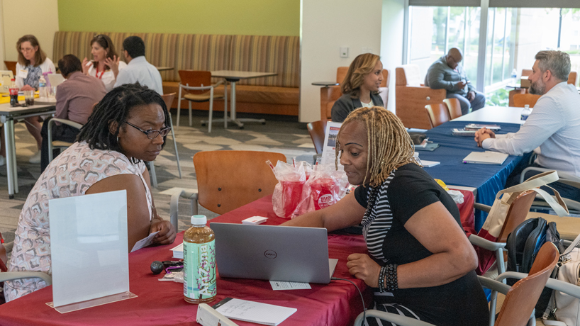 Tangela Williams-Spann of Belleville, Illinois, speaks with University of Missouri-St. Louis Human Resources specialist Cleola Butler about current job opportunities available at UMSL during the St. Louis Anchor Action Network's Juneteenth Hiring & Career Expo held Thursday at Edward Jones' North Campus in Maryland Heights, Missouri