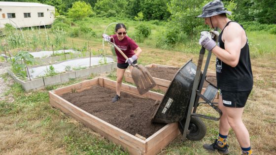 University of Missouri-St. Louis biology majors Nora Stith and Jesse Laseter add soil to one of the seven new garden beds added to UMSL's community garden