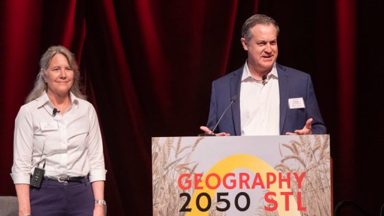 American Geographical Society President Marie Price and Chairman Christopher Tucker stand at a lecturn