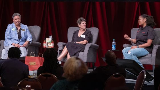 Adella Jones and Bethany Budde-Cohen listen to Cathy Jenkins during a discussion on stage